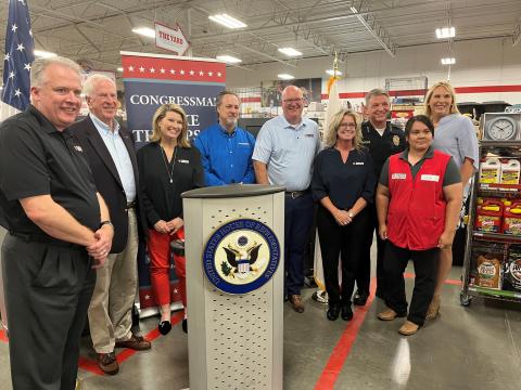 Thompson stands with members of the Tractor Supply Company at a press conference