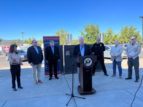 Rep. Thompson speaks at a podium in front of a gun safe